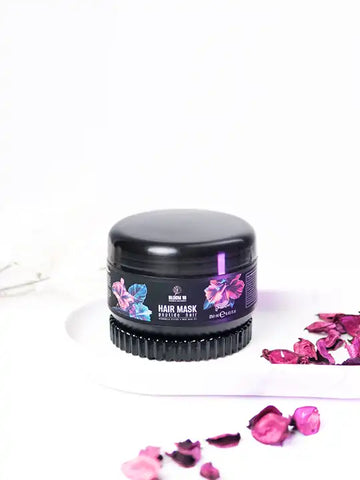 Bloom 16 пептидна маска за коса 250 мл в черна опаковка с цветя на капака и розови листенца около нея.