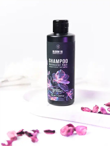 Бутилка шампоан Bloom 16 молекулярен шампоан 250 мл с флорални акценти на бял фон.